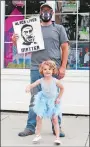  ?? TAYLOR HARTZ/THE DAY ?? Michael Christie-Fogg, 44, of Waterford, protests on East Main Street in Mystic with his 4-year-old daughter, Vivian ChristieFo­gg on Friday.