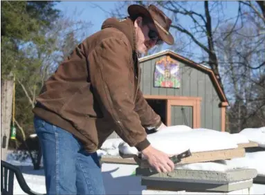  ?? ERIC BONZAR — THE MORNING JOURNAL ?? Ohio Department of Agricultur­e Apiary Inspector Jonathon Reichel checks one of the bee boxes in his apiary, Jan. 18. On Jan. 17, the Lorain County Commission­ers reappointe­d Reichel to head Apiary inspection­s within Lorain County for the third...