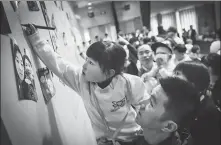  ?? PHOTOS BY XU KE AND PROVIDED TO CHINA DAILY ?? From left: A girl named Tiantian from Zhejiang province signs her name on the message board at a meeting held last year by the Shanghai Debra Butterfly Babies Care Center; Velo Zou, who was born in Shanghai in 2014, has spinal muscular atrophy; Lin Zhimiao, a doctor at Peking University Third Hospital, gives a young patient free treatment.