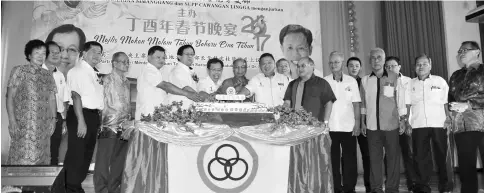  ??  ?? Dr Sim (seventh left) – flanked by Masir on his left and Harden – leads the cake-cutting ceremony at the Chinese New Year gathering.