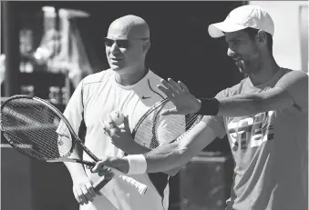  ?? CHRISTOPHE SIMON/AFP/GETTY IMAGES ?? Novak Djokovic, right, talks with his new coach Andre Agassi at a training session ahead of the 2017 French Tennis Open on Friday in Paris. Djokovic has been in a slump.