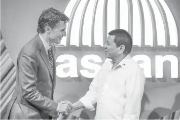  ?? AGENCE FRANCE PRESSE ?? Canadian Prime Minister Justin Trudeau shakes hands with President Rodrigo Duterte before the opening ceremony of the 31st Associatio­n of Southeast Asian Nations Summit in Manila.