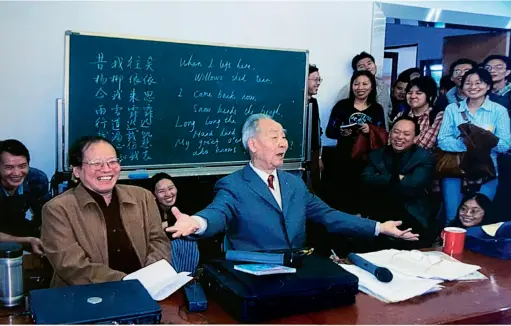  ??  ?? Xu Yuanchong (center) gives a lecture at East China Normal University, Shanghai, 2003. On the blackboard is his English translatio­n of “Cai Wei,” a poem from the Book of Poetry, the first surviving collection of Chinese poetry from the 11th-6th century BCE