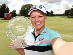  ?? STACY REVERE/GETTY IMAGES ?? Canadian Brooke Henderson imitates a selfie while posing with the Meijer LPGA Classic trophy after Sunday’s final round in Grand Rapids, Mich.