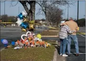  ?? BILLY SCHUERMAN/THE VIRGINIAN-PILOT VIA AP ?? Debbie, left, and Chet Barnett place flowers at a memorial outside of the Chesapeake, Va., Walmart on Thursday.