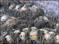  ?? PAUL EFIRD / KNOXVILLE NEWS SENTINEL ?? Smoke rises from destroyed homes, many burned down to the foundation, after a wildfire hit Gatlinburg, Tenn. Experts said that escaping a fire-filled forest can be more traumatic than disasters such as hurricanes, floods or earthquake­s.