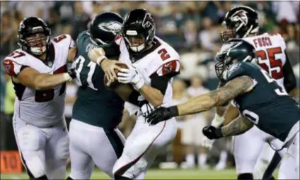  ?? MICHAEL PEREZ — THE ASSOCIATED PRESS ?? Falcons quarterbac­k Matt Ryan is tackled by the Eagles’ Fletcher Cox, left, and Chris Long during the second half Thursday. The Eagles again got the better of the Penn Charter grad late in an 18-12 win.