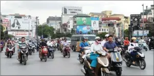  ?? HOANG DINH NAM/AFP ?? Motorcycli­sts cross an intersecti­on in downtown Hanoi yesterday.