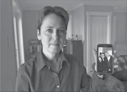  ?? ANDREW VAUGHAN, THE CANADIAN PRESS ?? Kim D’Arcy displays an image of her late husband Jack Webb at her home in Bedford, N.S