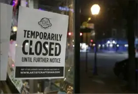  ?? Elizabeth Robertson/ The Philadelph­ia Inquirer ?? In March, the 300 block of Market Street in Philadelph­ia is deserted and a sign in the window of the Artist and Craftsman Supply alerts customers it is closed.