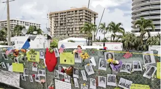 ?? CHARLES TRAINOR JR ctrainor@miamiheral­d.com ?? A memorial wall near the site of the Champlain Towers South condo building collapse in Surfside displays photos of people who died when the tower collapsed on June 24, 2021.