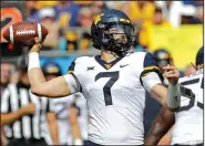  ?? AP/CHUCK BURTON ?? threw for 429 yards and five touchdowns Saturday to lead the No. 17 Mountainee­rs to a 40-14 victory over Tennessee in Charlotte, N.C.