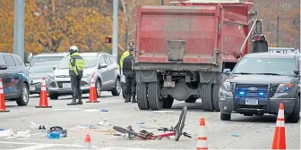  ?? MATT STONE PHOTOS / BOSTON HERALD ?? ‘SAD STORY’: Massachuse­tts State Police, above and below, investigat­e the scene where a bicyclist was hit and killed by a dump truck near the Museum Of Science in Cambridge yesterday.
