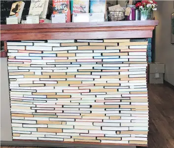  ?? TRACEE M. HERBAUGH/THE ASSOCIATED PRESS ?? Newtonvill­e Books in Newton, Mass., takes the backward-facing book trend to new level with a checkout counter made of rows of backward books glued into place.