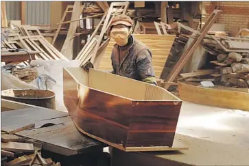  ?? Associated Press ?? A WORKER builds coffins at a shop in Johannesbu­rg, where business has been affected by a rise in prices for materials and a mandate to bury COVID victims quickly. A new wave of infections in South Africa is expected.