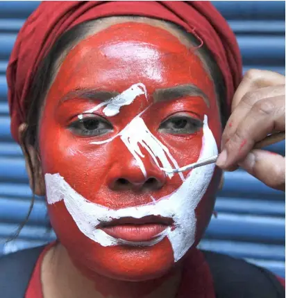  ?? PRAKASH MATHEMA/AGENCE FRANCE-PRESSE ?? VICTORY is all over a Nepal Communist Party (NCP) member’s face as she gets painted before taking part in a rally after the country’s Supreme Court ruling to overturn the prime minister’s decision to dissolve parliament, in Kathmandu.