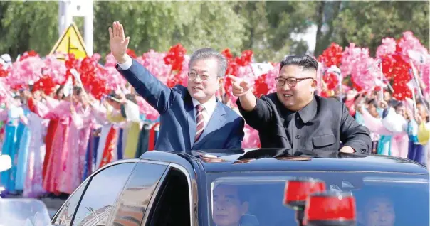  ??  ?? South Korean President Moon Jae-in and North Korean leader Kim Jong Un wave during a car parade in Pyongyang on Tuesday. — Reuters