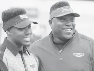  ?? STEPHEN M. DOWELL/ORLANDO SENTINEL ?? Warren Sapp II huddles with his father, Pro Football Hall of Famer Warren Sapp, at a signing day ceremony.