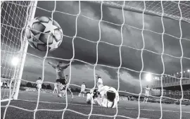  ?? MANU FERNANDEZ AP ?? Real Madrid goalkeeper Thibaut Courtois dives but fails to prevent Raphael Varane's own goal during a Champions League match against Shakhtar Donetsk.