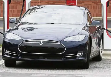  ?? — AP ?? Crucial model: A Model 3 car recharging at a Tesla charging station at Cochran Commons shopping center in Charlotte, North Carolina. Tesla aims to post a profit in each quarter this year, based on the expectatio­n that it will sell more Model 3s and continue to cut costs.