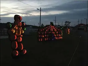  ?? LAUREN HALLIGAN - MEDIANEWS GROUP ?? A circus scene made of jack-o’-lanterns glows at dusk at the new Hollowed Harvest attraction at the fairground­s in Altamont.