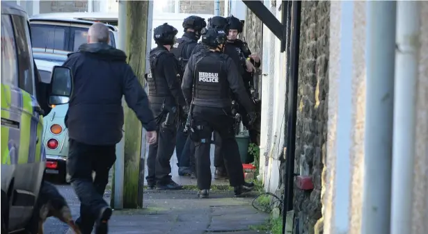  ?? Picture: Adrian White ?? Armed police at Benjamin Adam James Clarke’s Briton Ferry home in January last year.