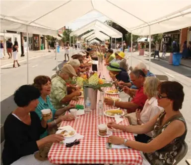  ?? CAROLA VYHNAK FOR THE TORONTO STAR ?? Warkworth’s popular Long Lunch, held on tables placed end-to-end on Main St., celebrates the area’s summer bounty and beauty and attracts food lovers from near and far. One organizer says volunteers are the key to making the feast successful.