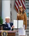  ?? OLIVIER DOULIERY / ABACA PRESS ?? President Donald Trump holds a signed proclamati­on as first lady Melania Trump looks on during the launch of the first lady’s initiative­s on Monday.