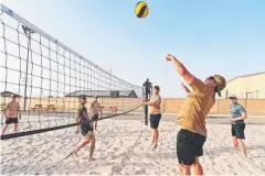  ??  ?? Members of Task Group Taji- 5 play beach volleyball after work.