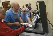  ?? BEN HASTY - MEDIANEWS GROUP ?? Robert S. Edris, center, of Mountain Edna, who works at the Tupehocken Township voting precinct, teams up with Lynda Jarsocrack of Spring Township’s 12th precinct and Allan Halle of Spring’s 11th precinct to learn about the county’s new tabulator.