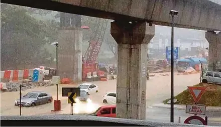  ??  ?? Heavy rains caused flash floods in front of the Setiawangs­a LRT station in Kuala Lumpur yesterday.