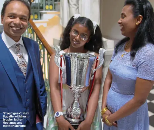  ??  ?? ‘Proud geek’: Nishi Uggalle with her trophy, father Neelanga and mother Shiromi