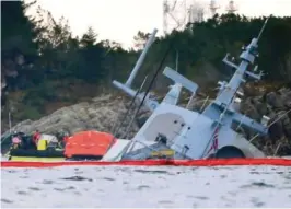  ?? FOTO: NTB SCANPIX ?? SUNKET: En båt med bergingsma­nnskaper ved den havarerte fregatten Helge Ingstad.