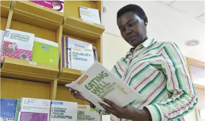  ??  ?? NAIROBI: Kenyan school teacher and breast cancer survivor Rose Kariuki reads pamphlets at the Faraja cancer care center on Monday. — AFP