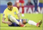  ?? AP photo ?? Brazil’s Neymar grabs his ankle during a 2-0 win over Serbia in the teams’ World Cup opener on Thursday. The team said Neymar had a sprained ankle.