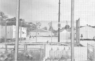  ??  ?? File photo shows detainees walking around the compound among water bottles inside the Manus Island detention centre in Papua New Guinea. — Reuters