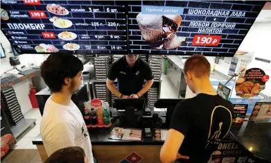  ??  ?? CUSTOMERS PLACE an order at a Domino’s Pizza restaurant in Moscow.