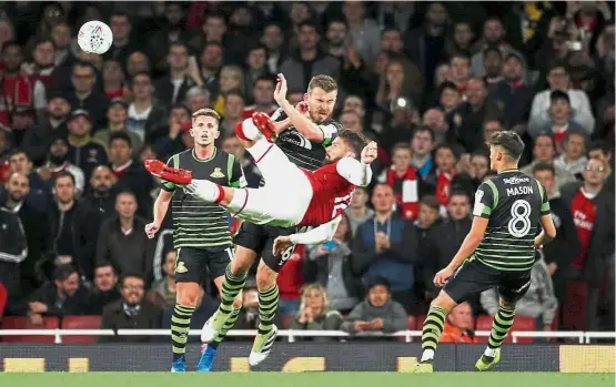  ?? — Reuters ?? Just do it: Arsenal’s Olivier Giroud going for the spectacula­r during the English League Cup third round match against Doncaster on Wednesday. The Gunners won 1- 0.