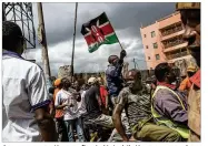  ?? ANDREW RENNEISEN / GETTY IMAGES ?? A man waves a Kenyan flag in Nairobi’s Kawangware slum Sunday after a visit from presidenti­al candidate Raila Odinga. Tensions remained high after a controvers­ial rerun election.