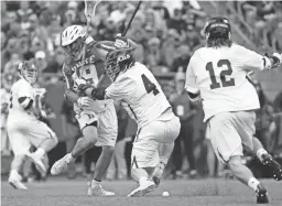  ??  ?? Duke’s Greg Pelton (19) and Yale’s John Daniggelis (4) battle for the ball during the first half of an NCAA college Division I championsh­ip final lacrosse game Monday in Foxborough, Mass