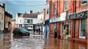  ?? — AFP ?? Members of emergency services check shops on a street in Tenbury Wells, England, on Monday, after the River Teme broke its banks amid Storm Dennis.