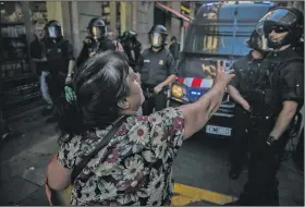  ?? AP/SANTI PALACIOS ?? A woman confronts Catalan regional police officers Sunday in Barcelona after a rally against Catalonia’s independen­ce from Spain. Organizers said the rally’s goal was to defend Spain’s unity and reject “an unpreceden­ted attack in the history of...