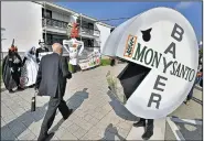  ?? AP/MARTIN MEISSNER ?? Activists protest Friday outside Bayer AG headquarte­rs in Bonn, Germany, against Bayer’s planned $66 billion takeover of Monsanto Co. The companies reached a settlement Tuesday with the Justice Department that clears the last major regulatory hurdle to...