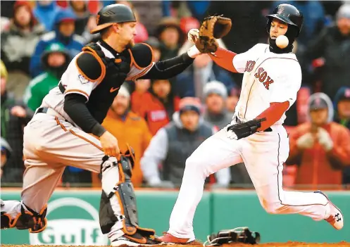  ?? PHOTO AFP ?? Andrew Benintendi a tenté de battre de vitesse le relais au marbre, hier, en septième manche. La manoeuvre a échoué pour le joueur des Red Sox, qui a été retiré par le receveur des Orioles Caleb Joseph.