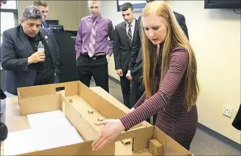  ?? Deana Carpenter ?? Bethel Park High School student Jessica Viehman explains her team’s project to Pedro Quiroga, left, owner of EAFab Corp. in Oakdale. In the background are her teammates, Eric Wenger (wearing purple shirt) and to his right, Justin Sackett and Tom Kennedy.