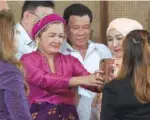  ?? — AFP ?? Philippine President Rodrigo Duterte poses for a selfie with women at Malacanang Palace in Manila on Monday after unveiling a law granting greater autonomy to the south.