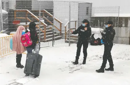  ?? LARS HAGBERG/AFP VIA GETTY IMAGES ?? RCMP officers greet refugees at the Roxham Road border crossing in Champlain, N.Y., on March 25, 2023. The premier has decided to appeal a court ruling that overturned a ban on children of asylum seekers attending subsidized daycare in Quebec.