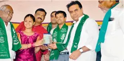  ??  ?? A girl in Mustafanag­er donates `30,000 that she had saved over the years to minister K.T. Rama Rao for the Rythu Bandhu Scheme on Friday. — DC