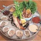  ?? ?? A Lil’ Fancy Ice Chilled Shellfish Tower features a half dozen oysters, blue crab claws, lobster and variety of sauces April 1 at Fancy’s Fish House in Memphis.