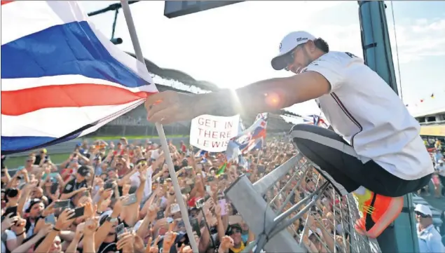  ??  ?? EN LO MÁS ALTO. Hamilton terminó su fin de semana en Hungría aclamado por la afición después de imponerse a Verstappen con una decisión estratégic­a clave de Mercedes.